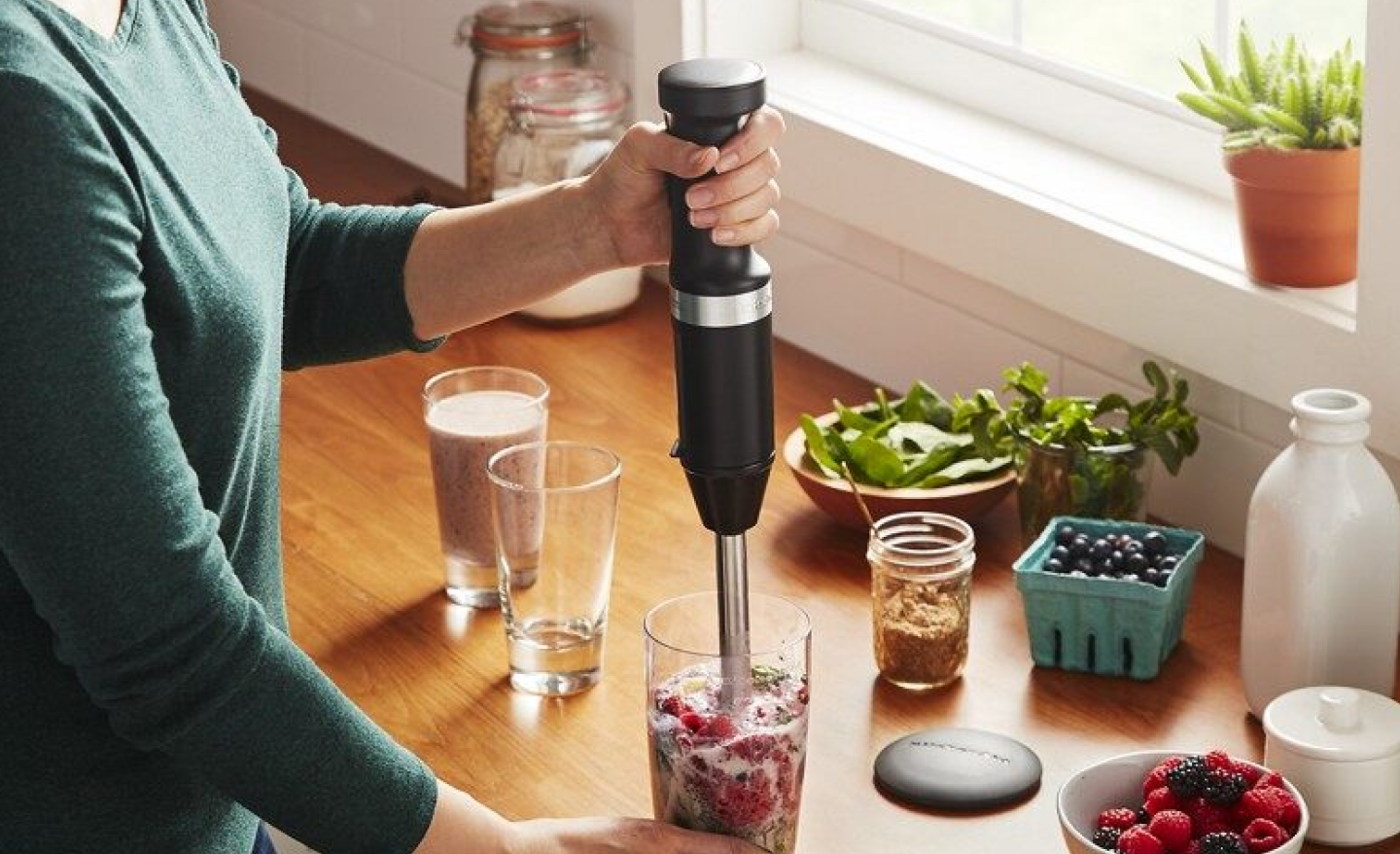 Woman blending a smoothie in a drinking glass