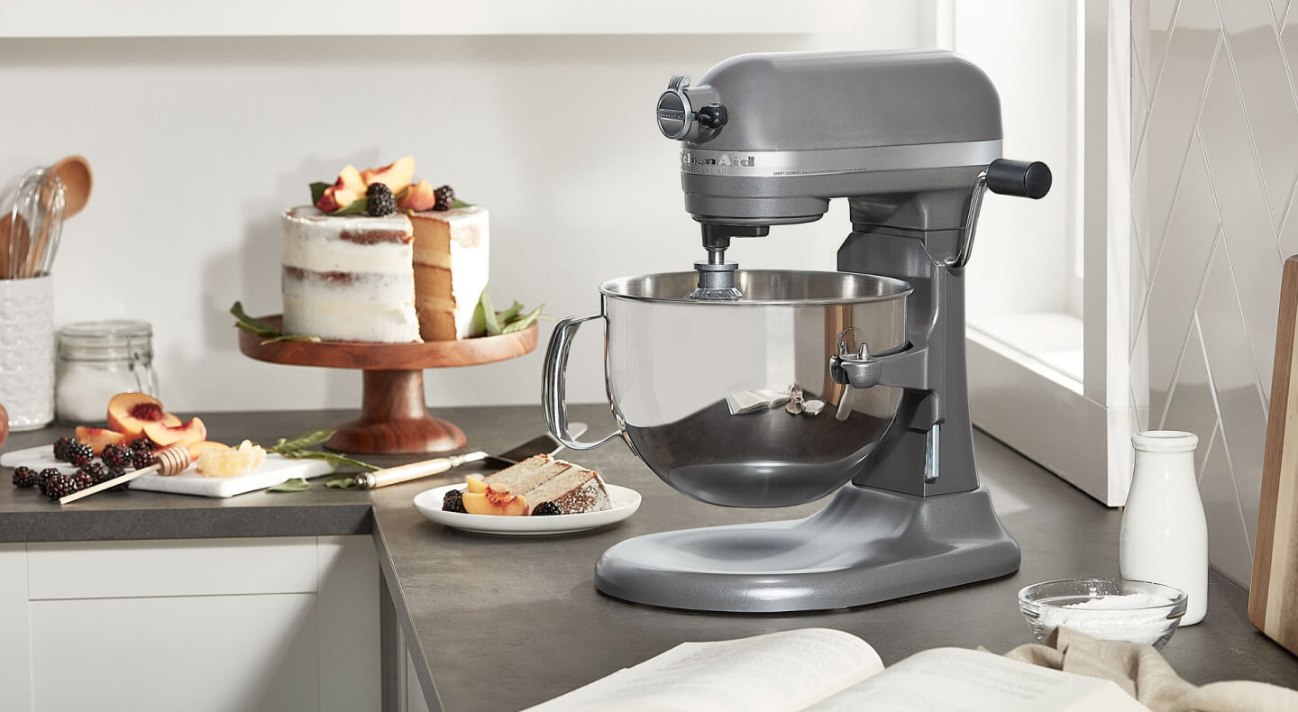 KitchenAid® bowl lift stand mixer next to layer cake on cake stand 