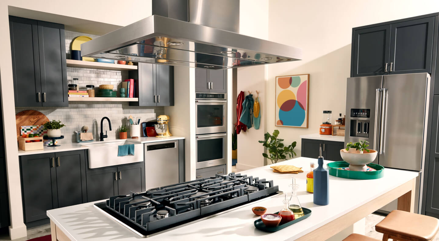 KitchenAid® wall oven, cooktop, range hood, dishwasher and refrigerator appliance suite in a modern kitchen