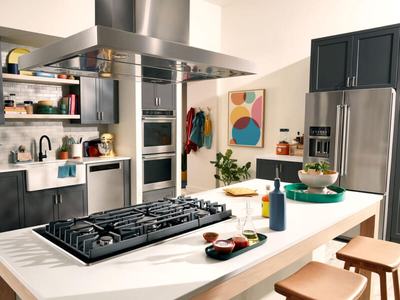 KitchenAid® wall oven, cooktop, range hood, dishwasher and refrigerator appliance suite in a modern kitchen