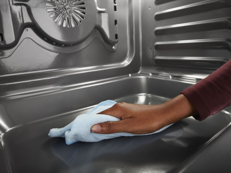 Person cleaning the inside of an oven