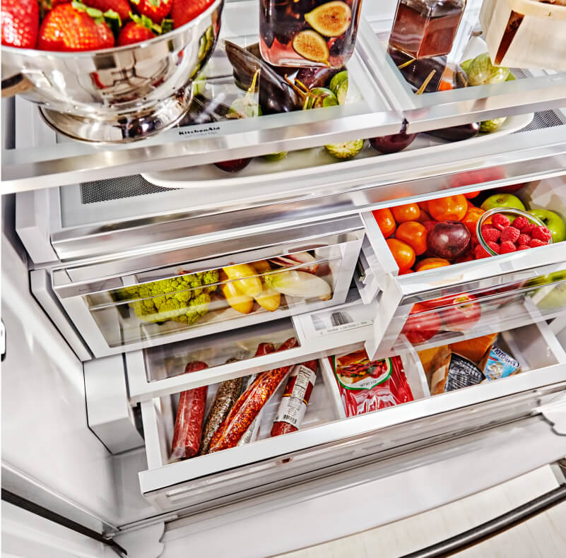 Stocked refrigerator with fruits and vegetables stored in crisper drawers