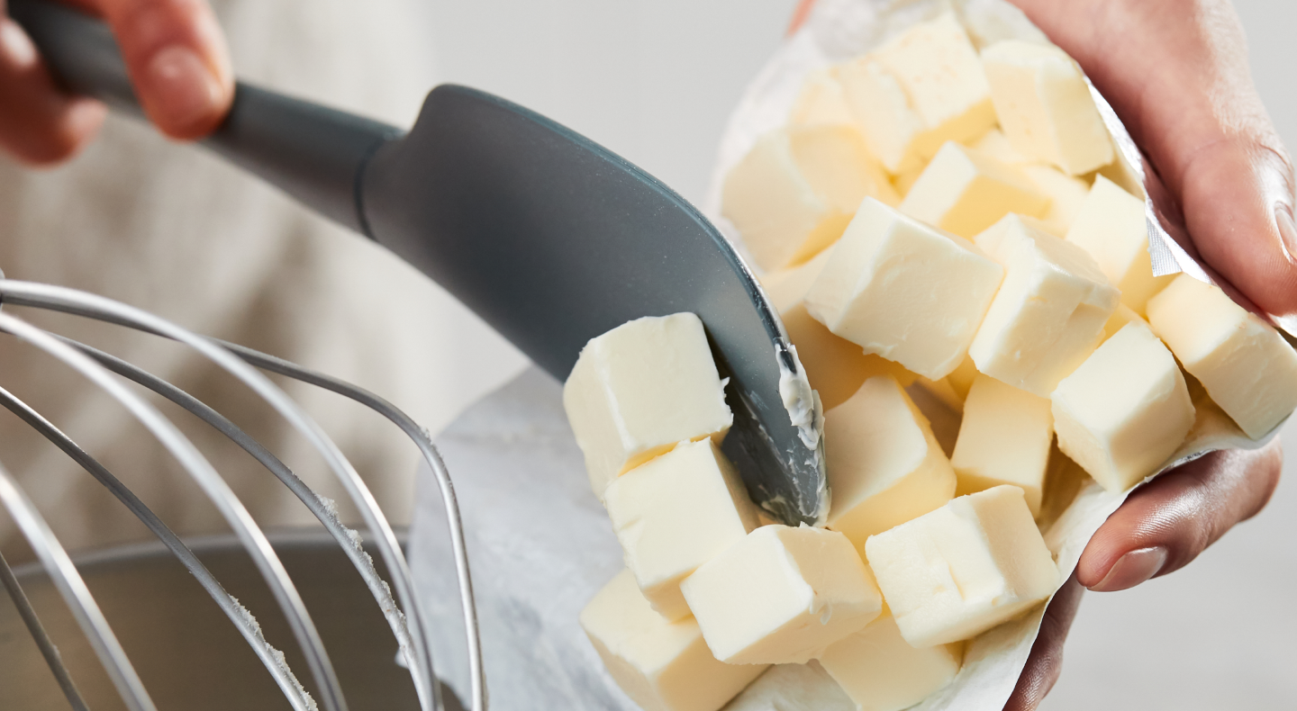 Person using spatula to put slices of butter in a bowl