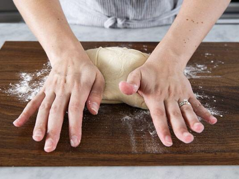 A person kneading bread by hand