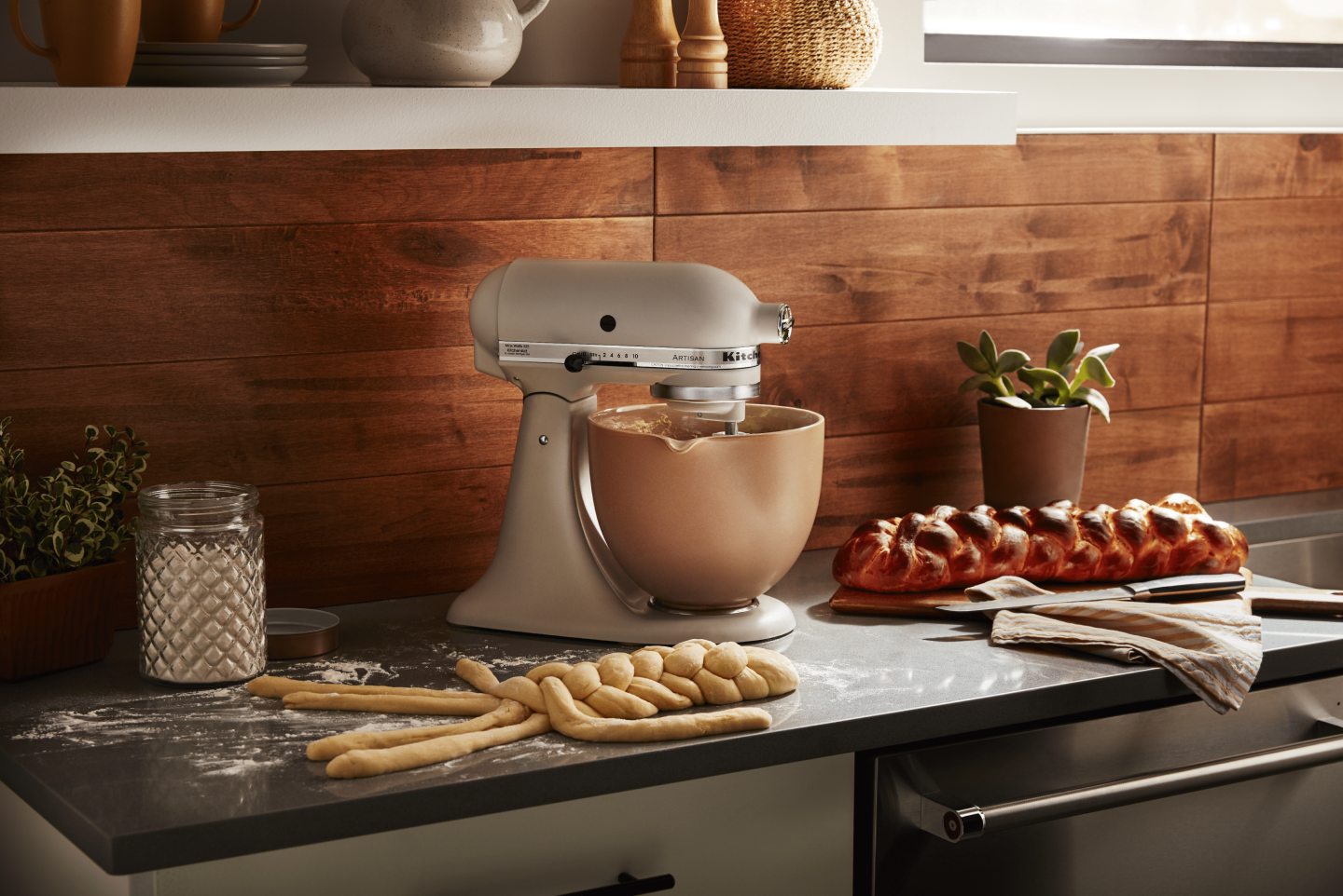KitchenAid® Stand Mixer with freshly baked challah and challah dough being braided in front of the mixer 