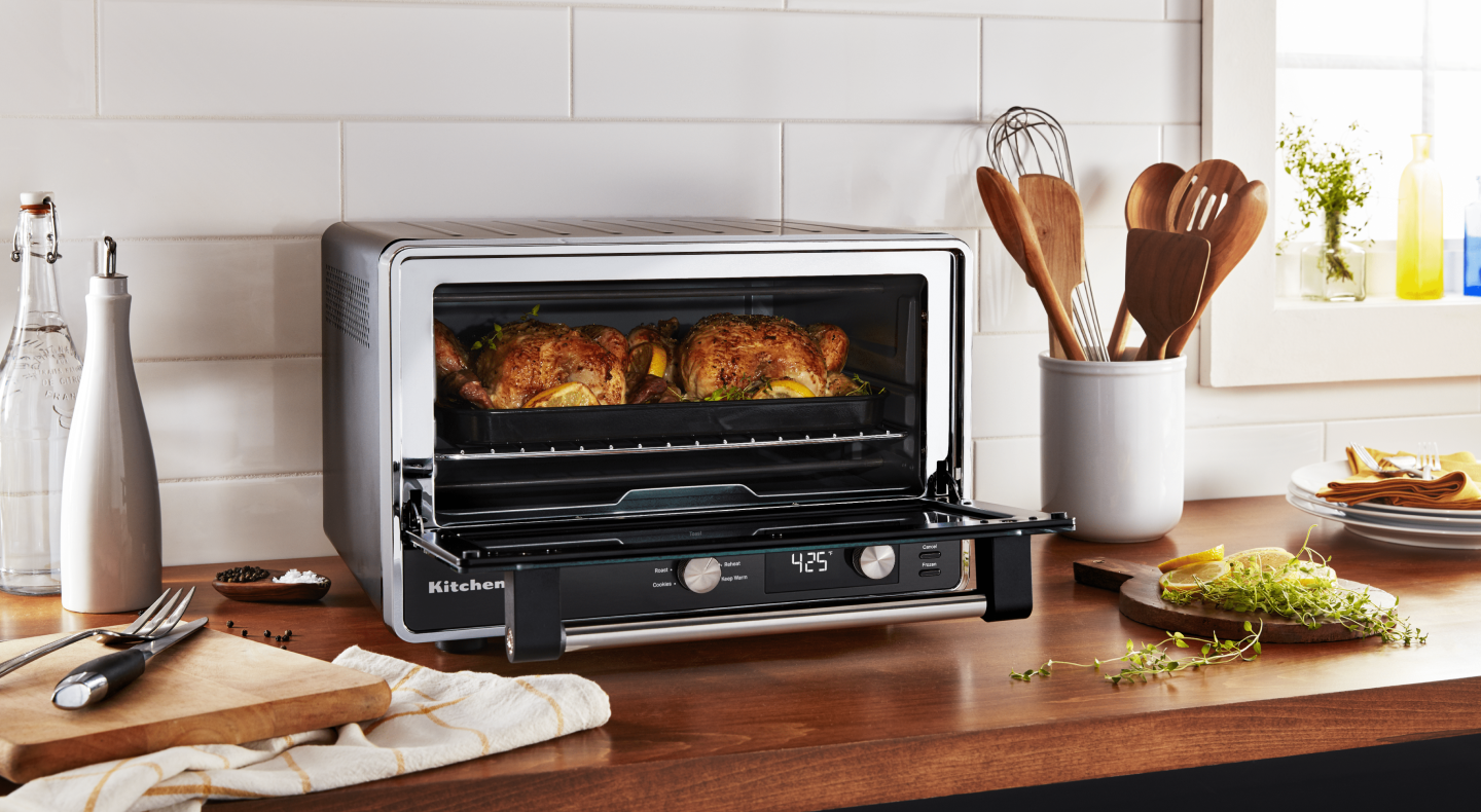 Two whole chickens roasting in a KitchenAid® countertop oven
