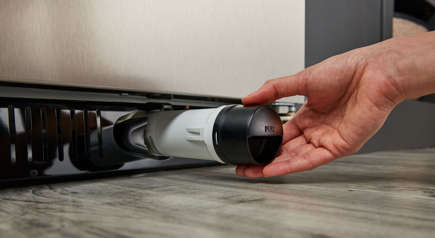 Person removing refrigerator water filter