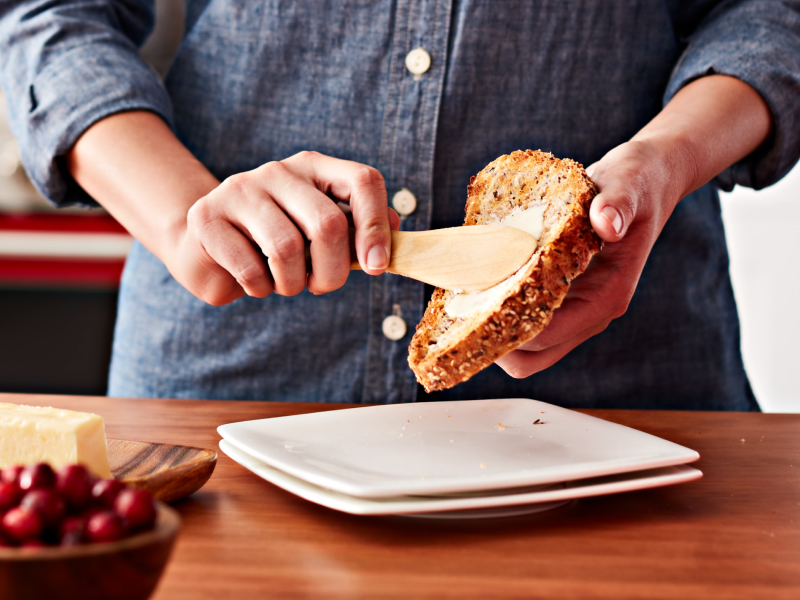Person buttering a slice of bread