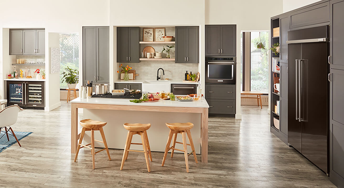 An open-concept kitchen with dark cabinetry and appliances