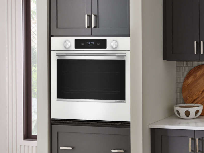 Smart wall oven surrounded by black cabinetry