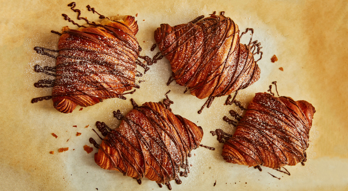 A set of eclairs with chocolate drizzled over them
