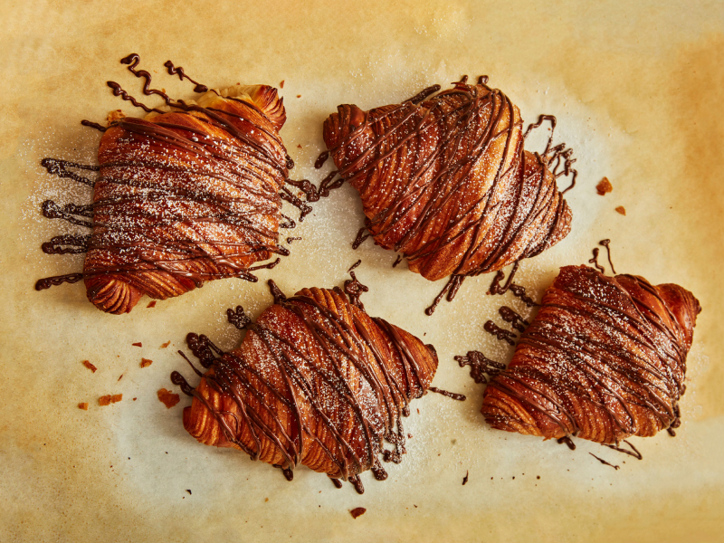 A set of eclairs with chocolate drizzled over them