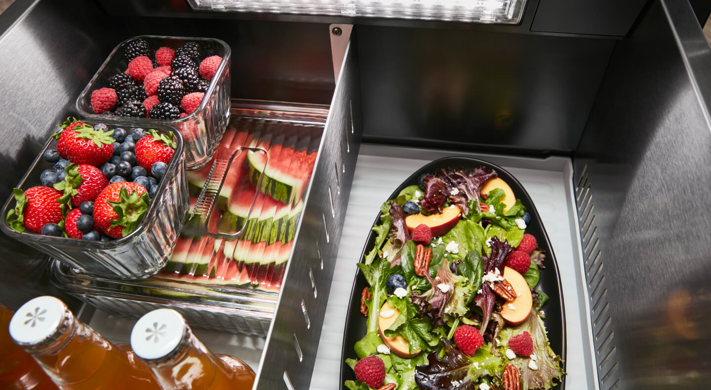 Fresh fruit and a salad stored inside a refrigerator