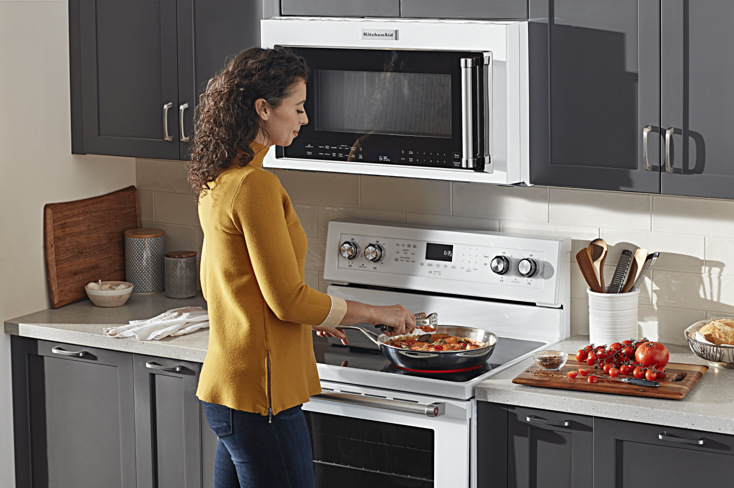 Person adding ingredients to a skillet on an electric stovetop 