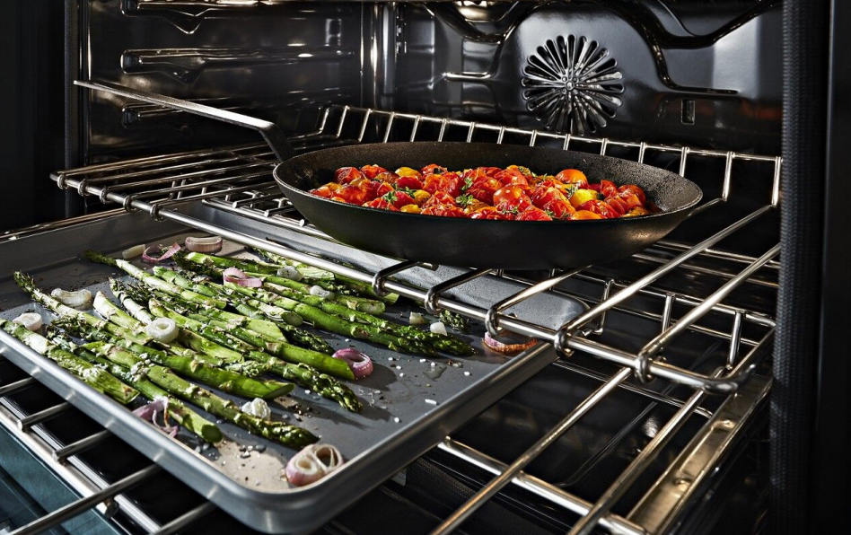 Convection oven open with several dishes cooking