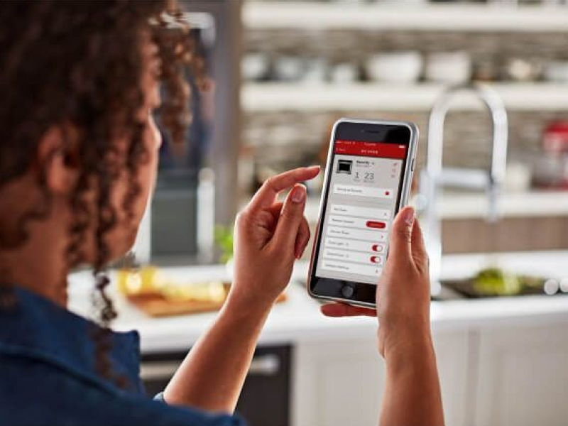 A person using the KitchenAid® smart appliance app on a mobile device