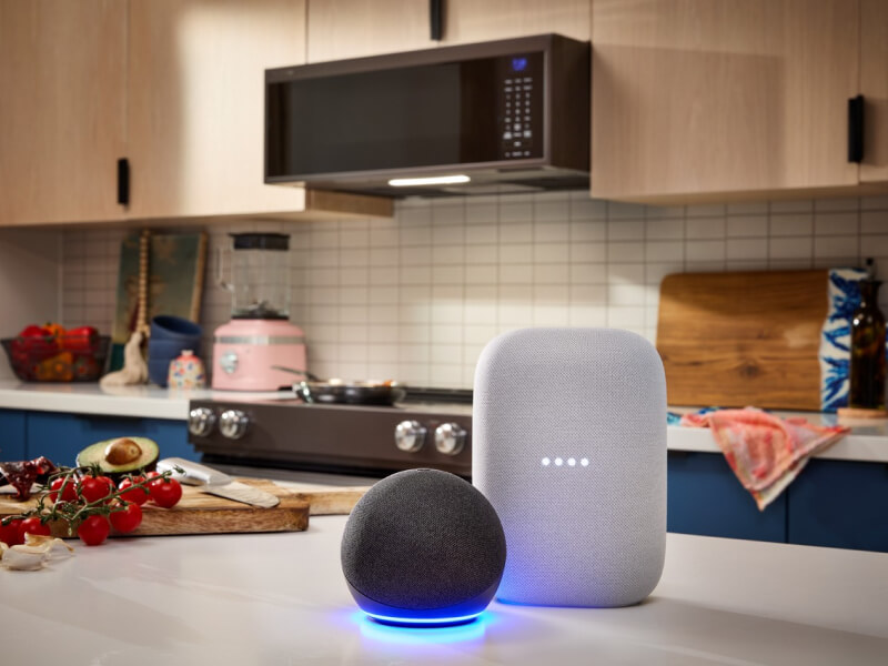 Personal assistant devices on a kitchen island in front of an over-the-range microwave
