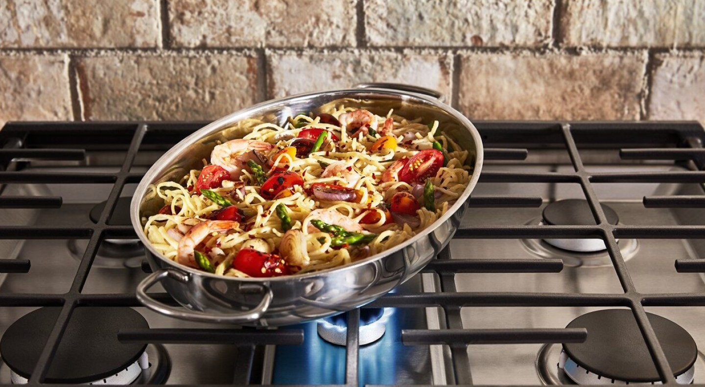 Pasta and vegetables in a pan on a range