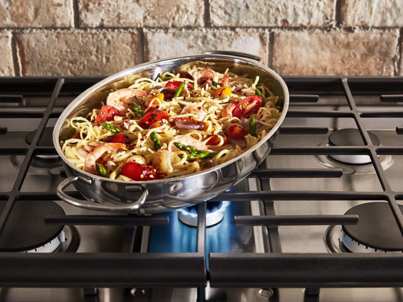 Pasta and vegetables in a pan on a range