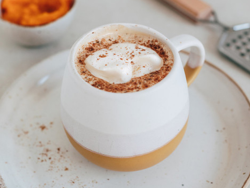 Whipped coffee in a mug on a tea plate
