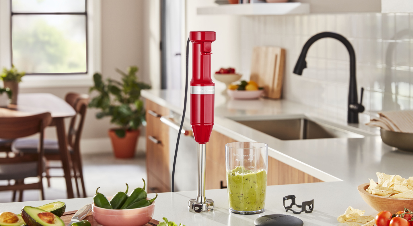 KitchenAid® hand blender next to green smoothie on countertop