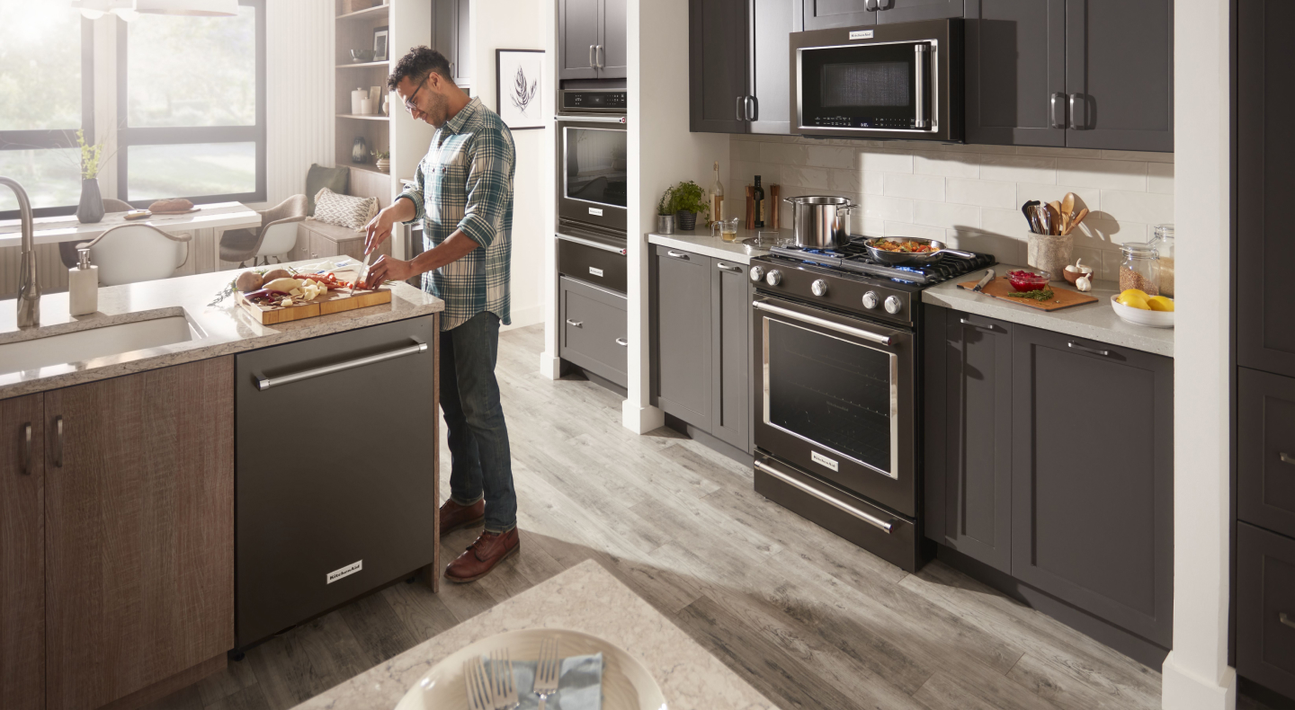 Person cutting vegetables at a kitchen island