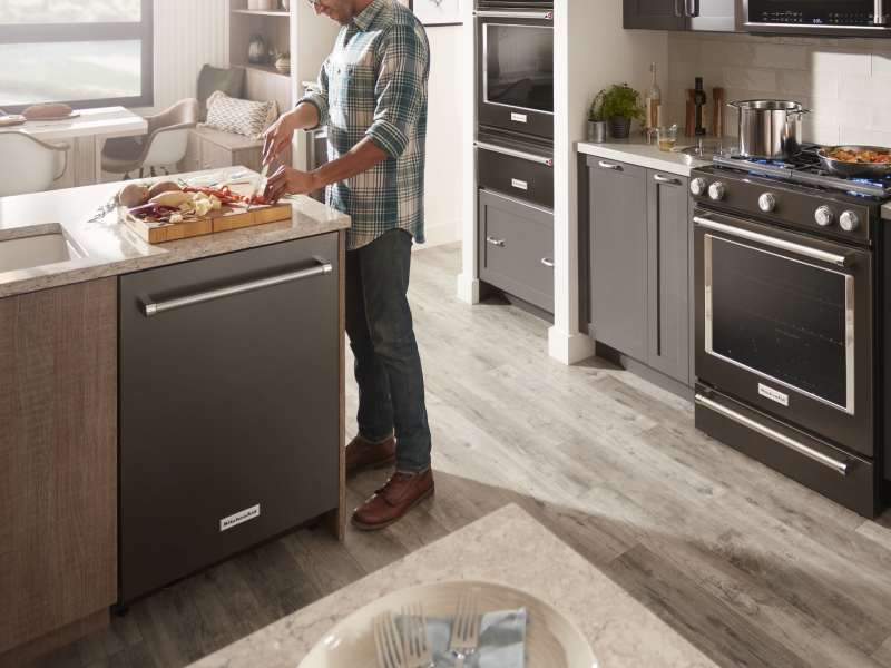 Person cutting vegetables at a kitchen island