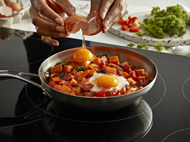 A person cracking an egg into a dish
