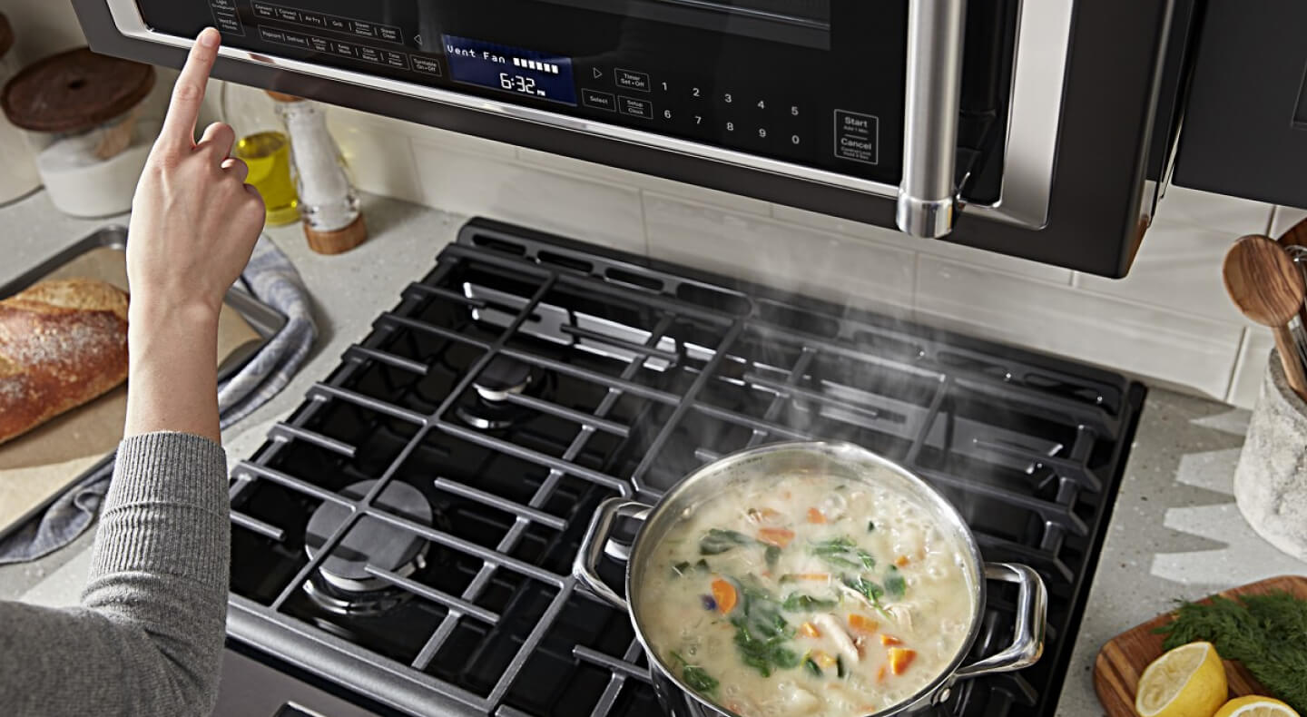 Person selecting a setting on a microwave hood combination
