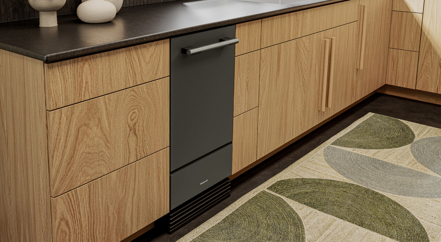 KitchenAid® ice maker built into light wood cabinetry 