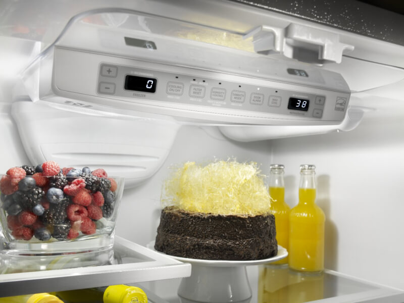 Dessert, fruit and glass bottles in a refrigerator