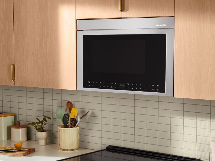 KitchenAid® flush built-in over-the-range microwave installed in wood cabinets.