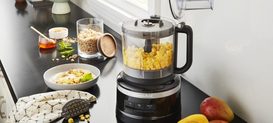 Black KitchenAid® Food Processor on counter surrounded by smoothie ingredients