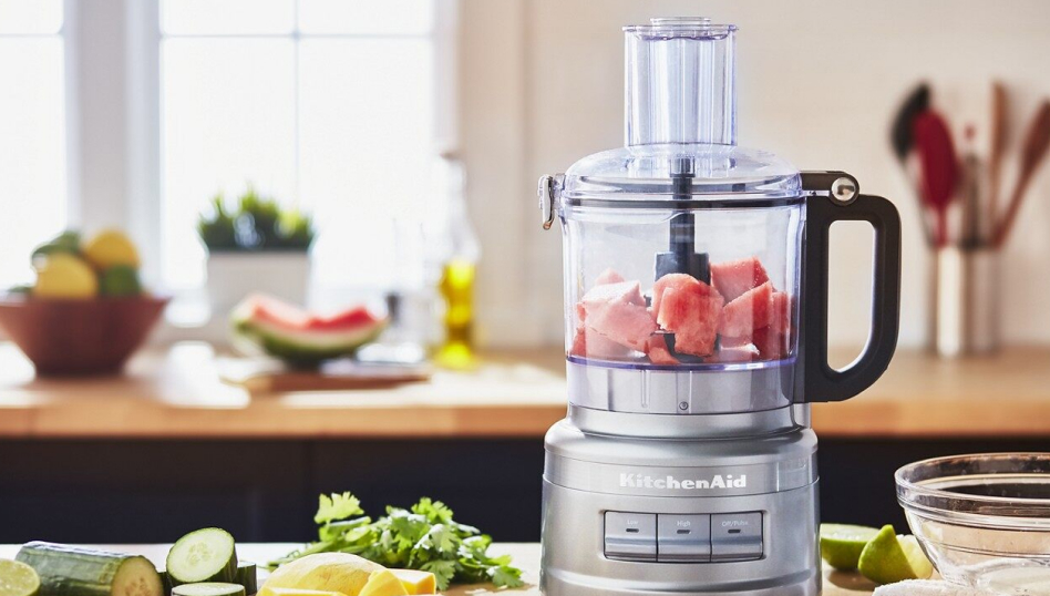 Bright kitchen featuring a silver KitchenAid® Food Processor with work bowl containing watermelon