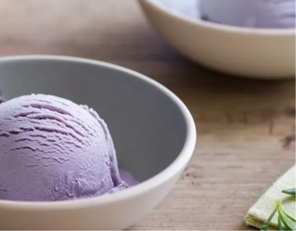 White ceramic bowl with single scoop of lavender honey ice cream.