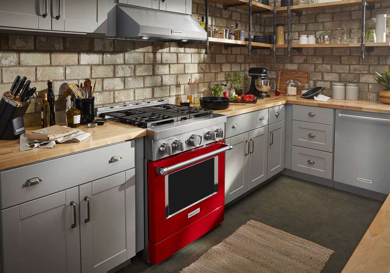 A fully equipped kitchen with a Red KitchenAid® Gas Range