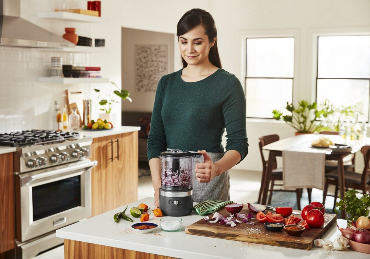 Woman dicing purple onion with gray food processor
