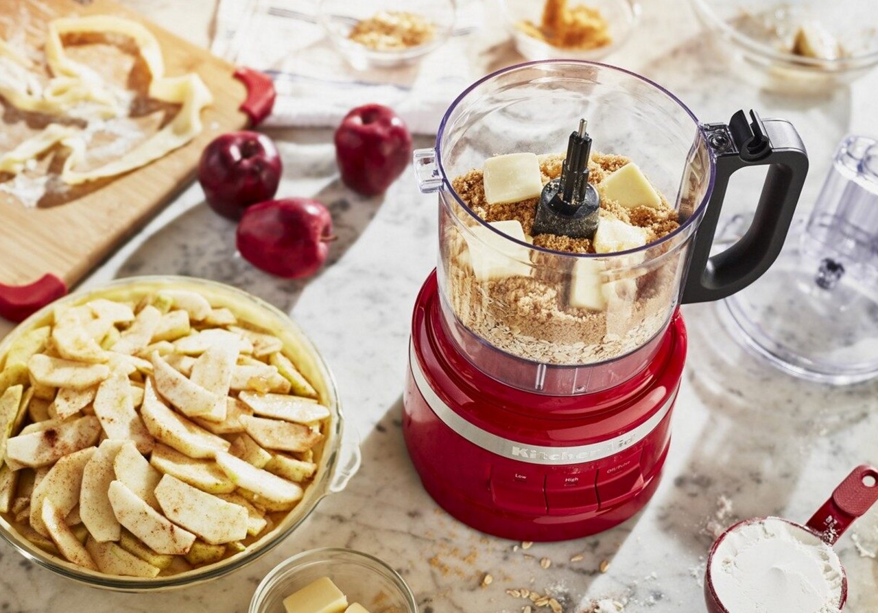 Red food processor filled with ingredients for pie crust