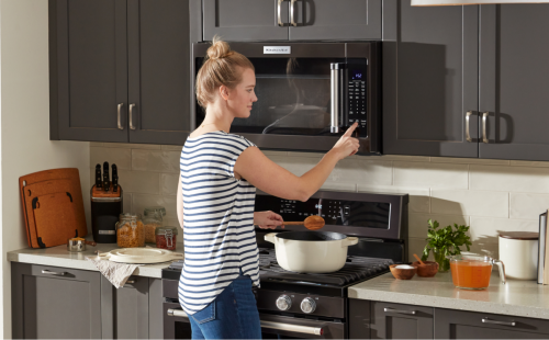 A person using a KitchenAid® microwave