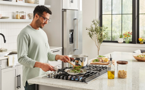 Person cooking vegetables on a kitchen island cooktop