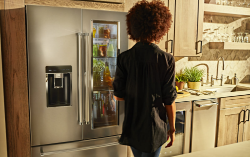 Woman looking into an open refrigerator