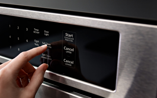 Person selecting cleaning cycle on oven