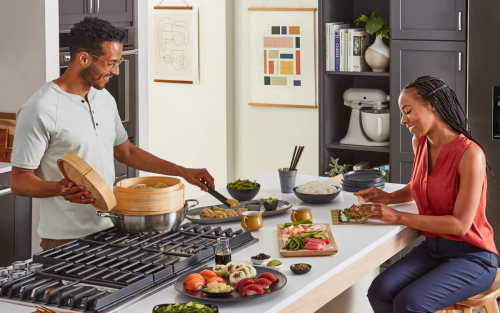 A man and woman cooking together at a kitchen island