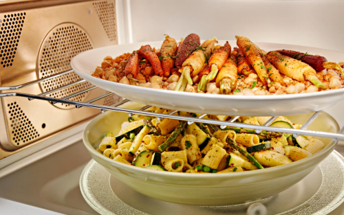 Two plates of food cooking inside a convection microwave