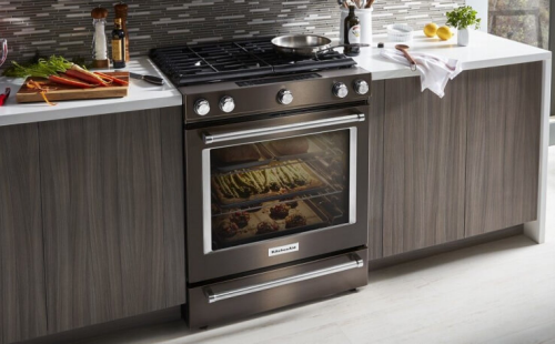 Black stainless steel KitchenAid® range next to dark cabinets