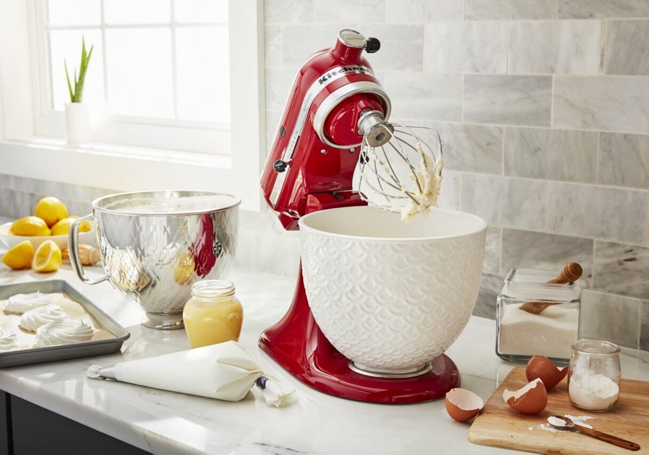 Red KitchenAid® stand mixer with whisk attachment and ceramic white ceramic mixing bowl