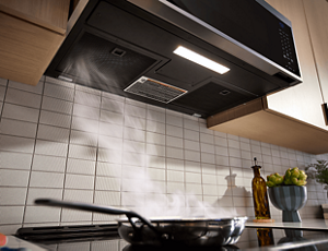 A KitchenAid® Over-the-Range Microwave whisking steam away from the cooktop. 