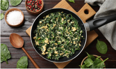 A skillet filled with cooked spinach and ground chicken.