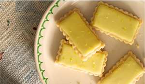 Four shortbread cookies glazed in a pale yellow yuzu glaze.