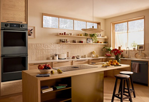 A modern kitchen with a KitchenAid® wall oven, dishwasher and downdraft cooktop